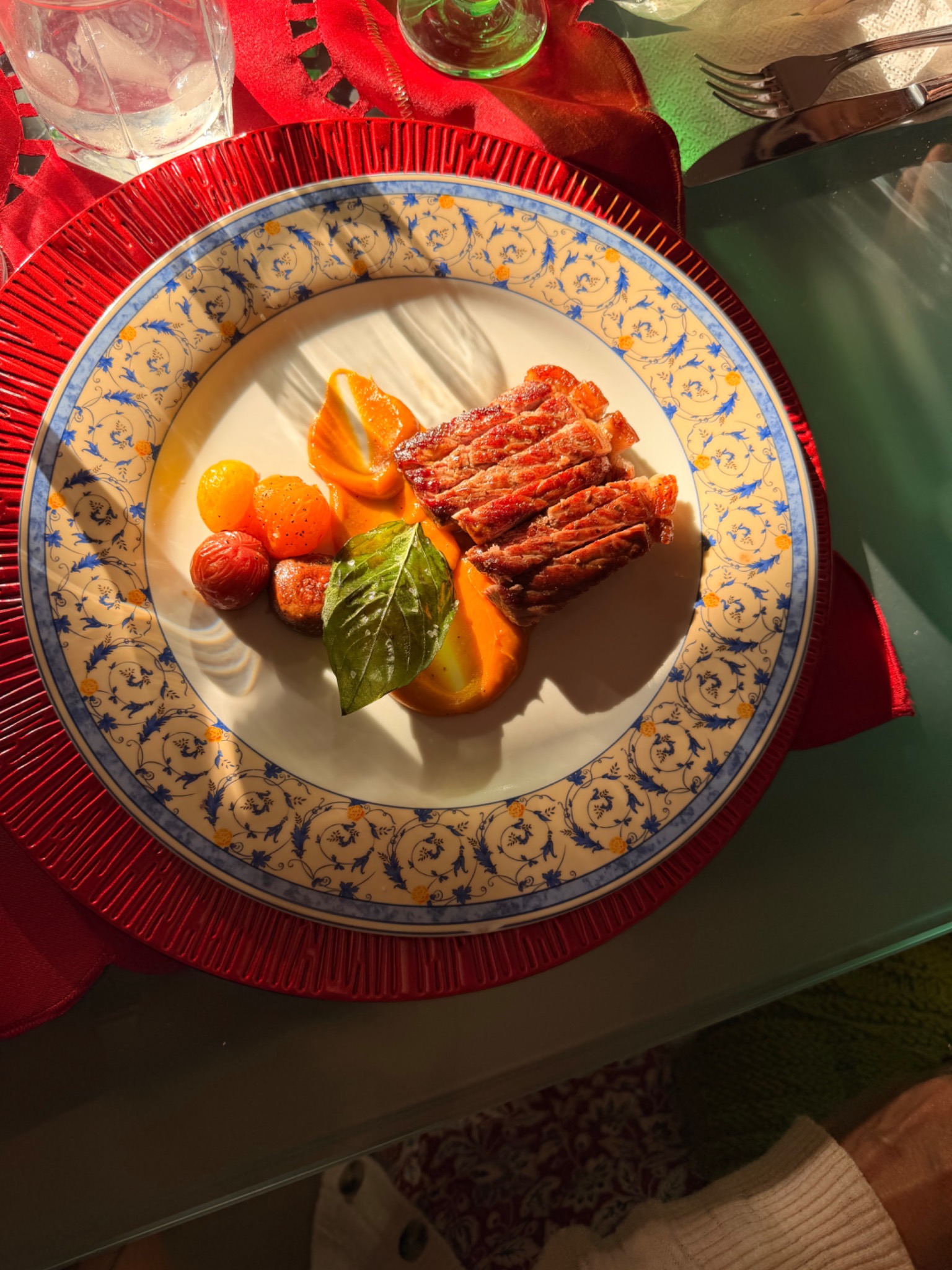 Ribeye with red-wine demi-glace, roasted squash, tomato-carrot purée, fried basil and cherry tomatoes